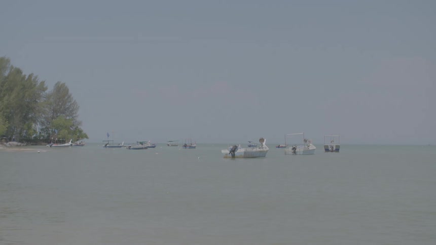 Boats floating off a shoreline on a clear day