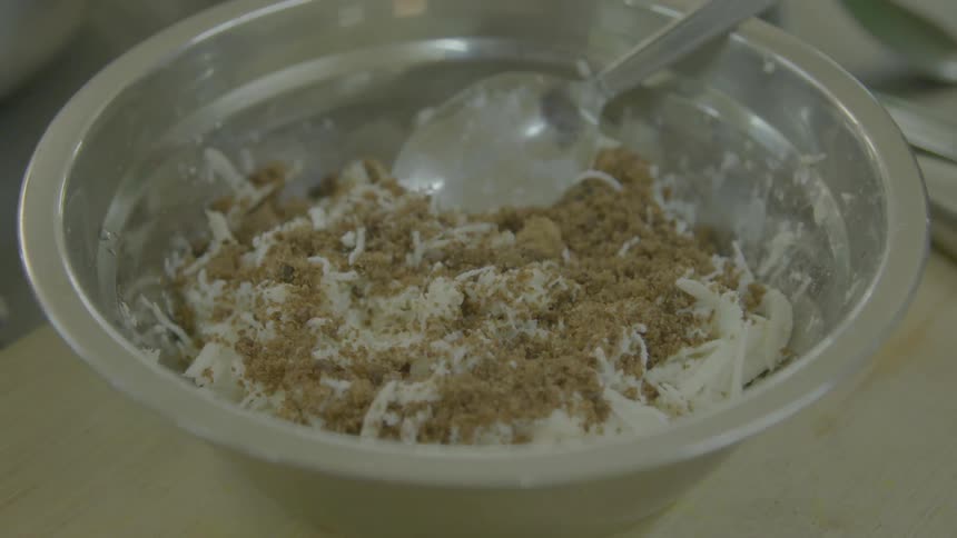 A bowl of food with a spoon in it sitting on a counter in a house