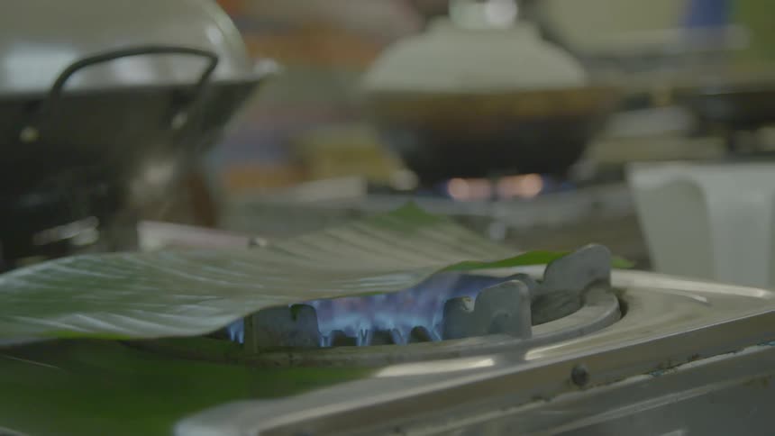 Food being heated up over an open flame on a stove