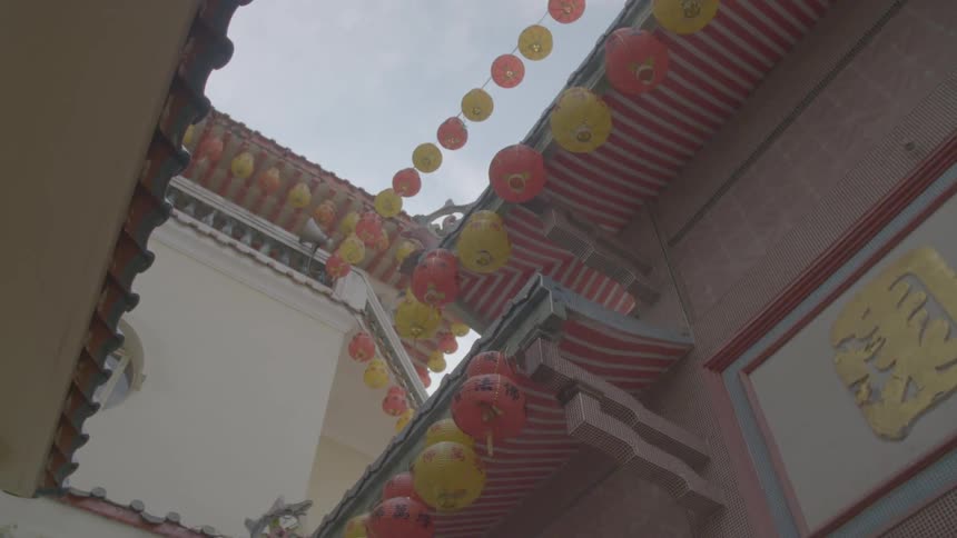 Chinese lanterns hanging from an asian building in the daytime