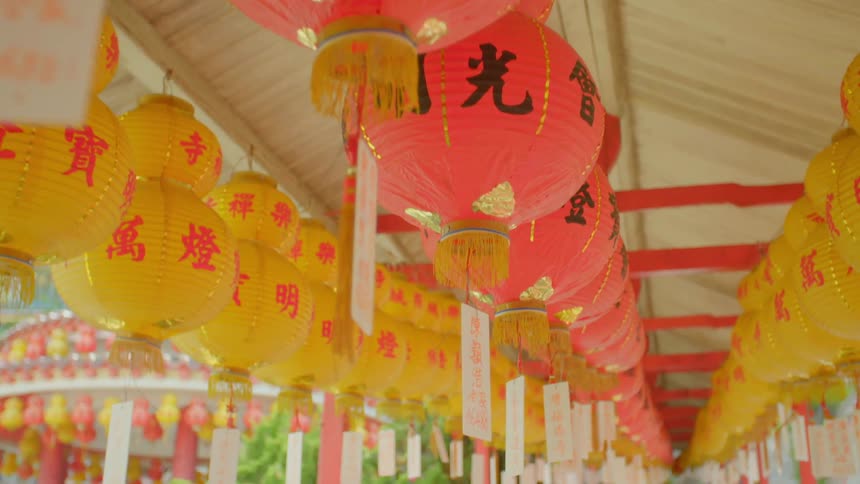 Rows of chinese lanterns hanging from a building on a summer day