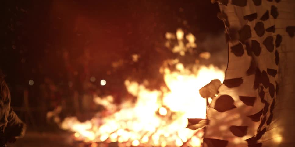 People gathering around a large bonfire