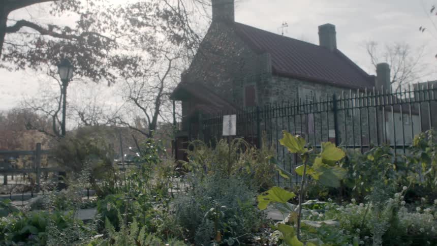 View of a stone home behind an iron fence