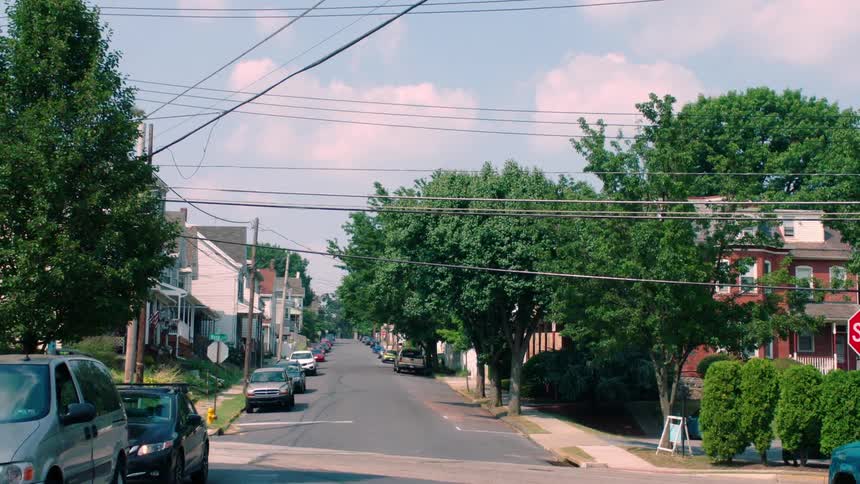 A car drives past a residential street