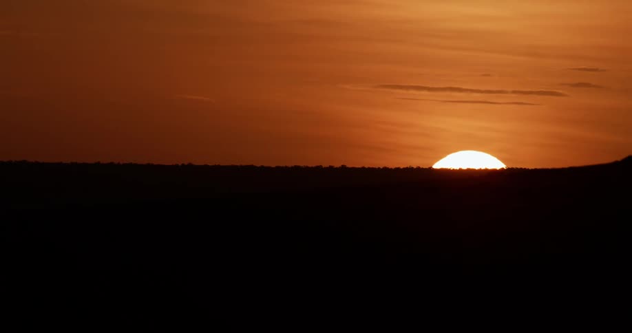 The sun sets behind the hill