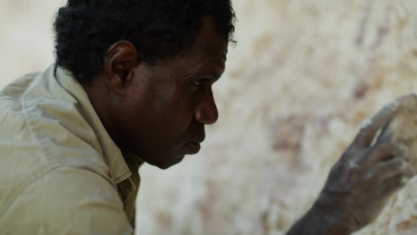 An aboriginal man gathering white ochre for paint