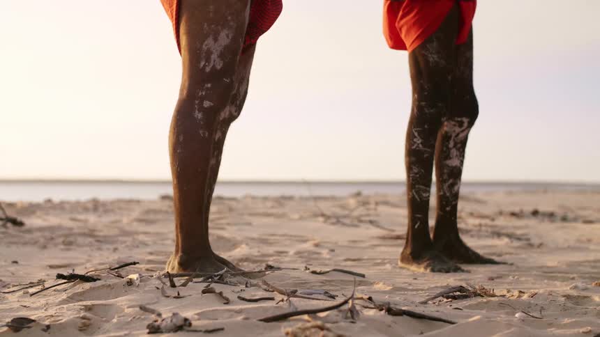 Three men standing on a beach
