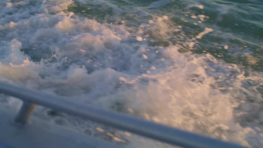 A speedboat creates waves as it sails through the ocean
