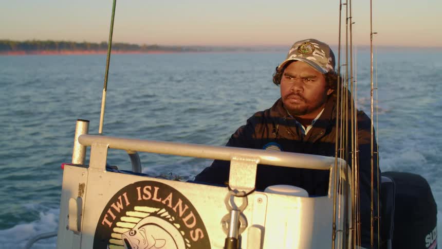 A man driving a boat on a river