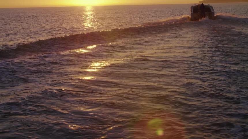 The sun shining down on a boat in the ocean
