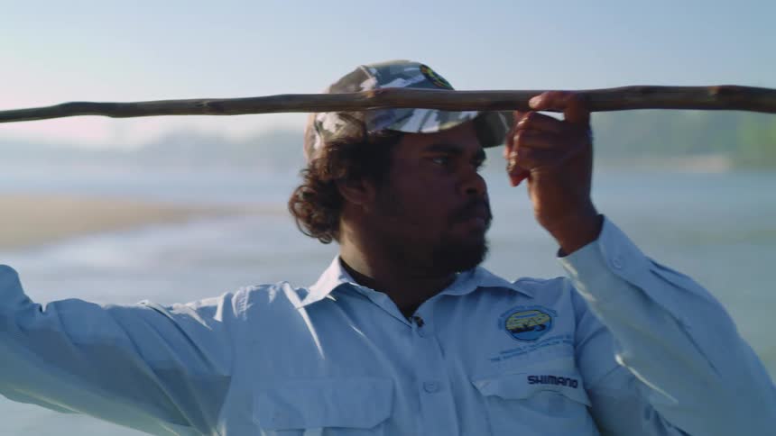 A man throws a spear while fishing