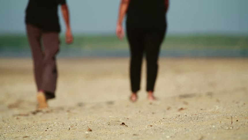 Two women walking down the beach