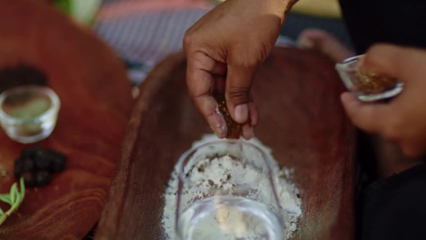 A person is mixing some spices in a bowl
