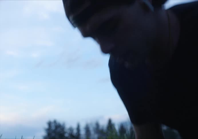 Man does push ups outdoors with forest in background