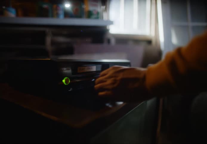 A person inserts a vhs tape into the vcr