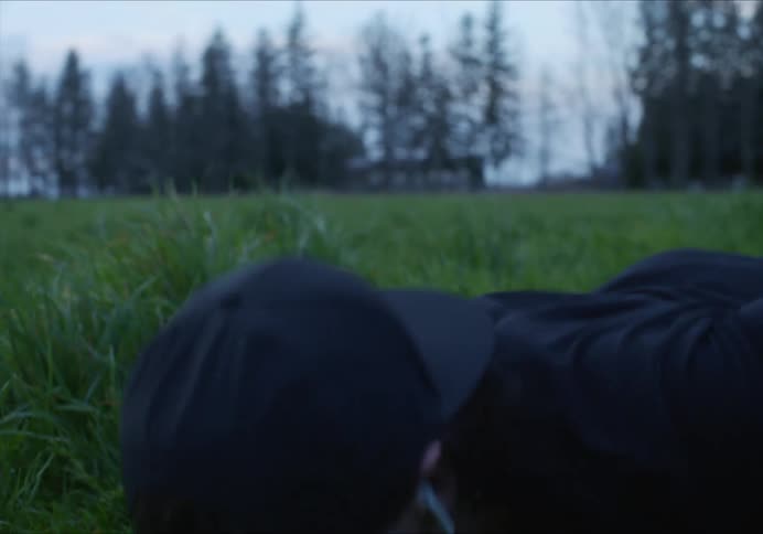 Man does push ups in field near woods