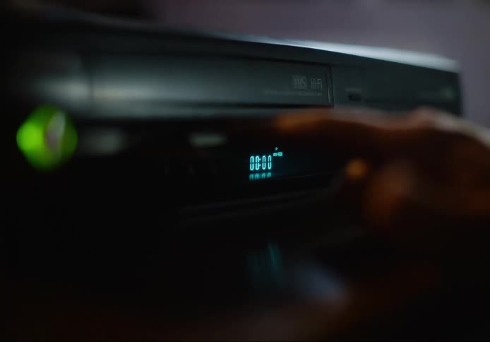 A person presses the button on the vcr