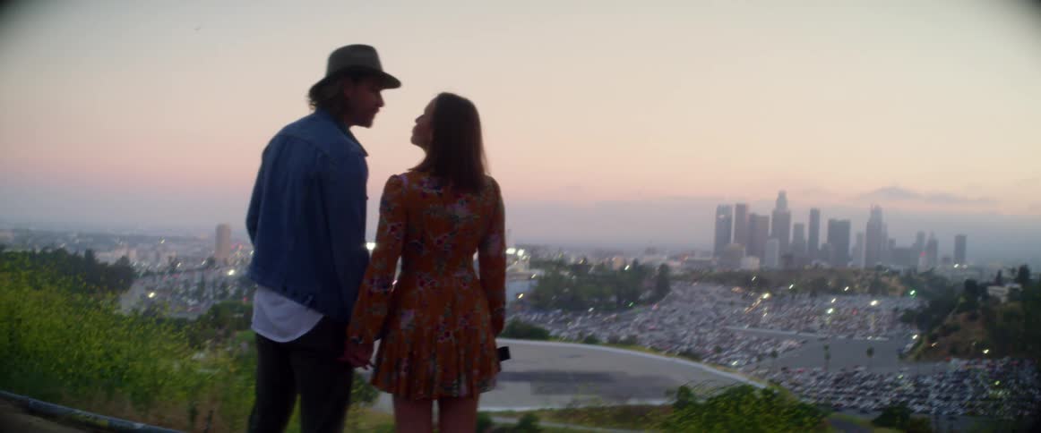 A man and woman kissing overlooking a city