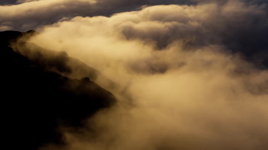 A mountain range with clouds