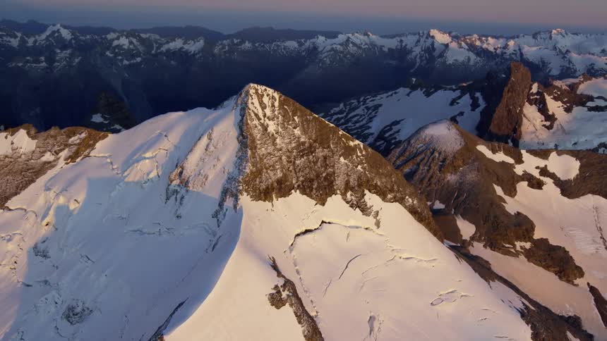Aerial view of snow covered mountains at dusk