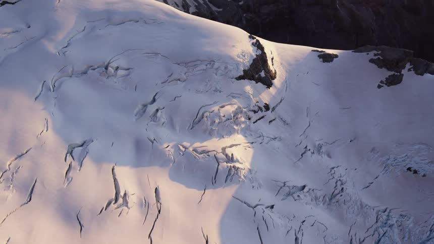 Rough mountain terrain peaks out from under thick snow