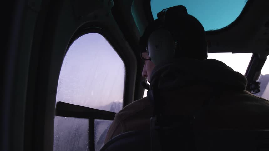 A man is riding in a helicopter