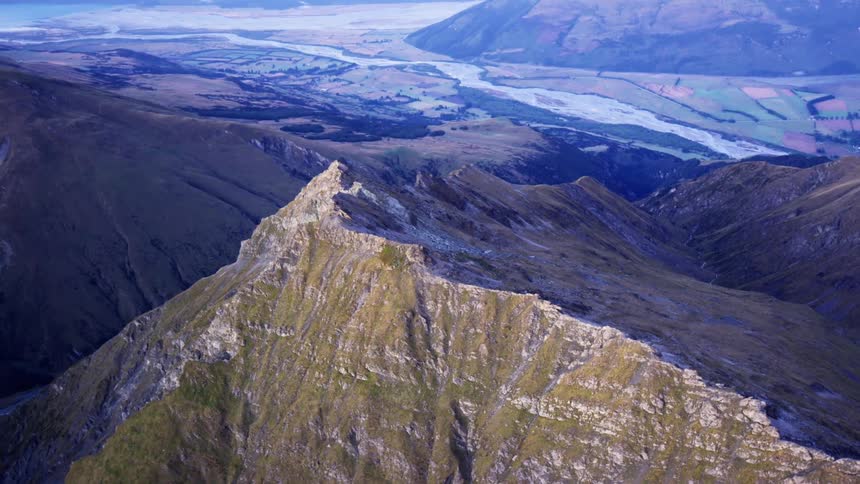 A stone mountain range covered in thin vegetation