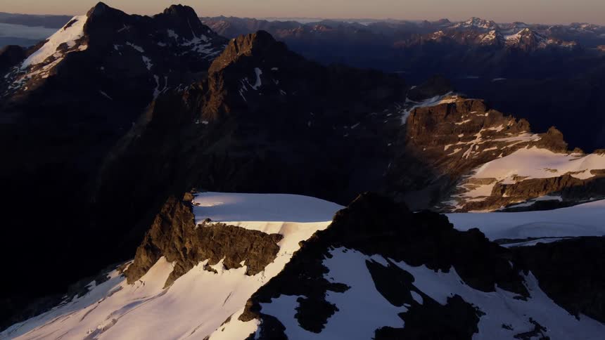 The mountain range has snow all over