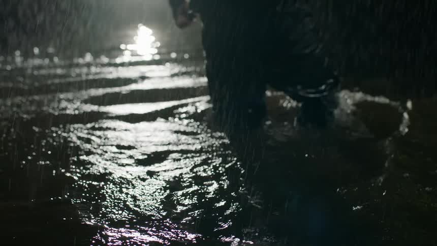A person is wading through the flood waters