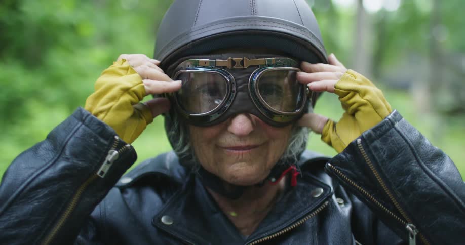 An elderly woman puts goggles on