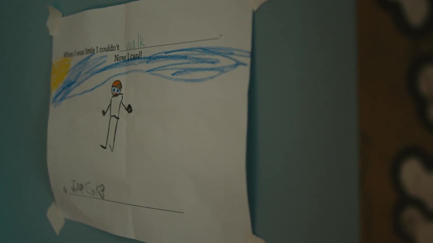 A childs crayon drawing taped to a wall