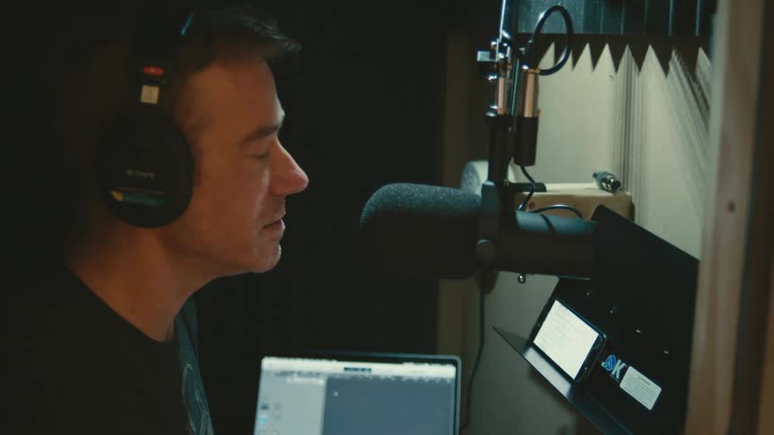 A man is singing in a studio