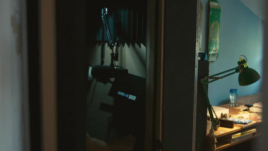 A man is adjusting his recording equipment in the studio