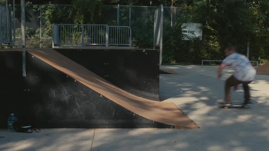A man riding a skateboard up a ramp and jumping