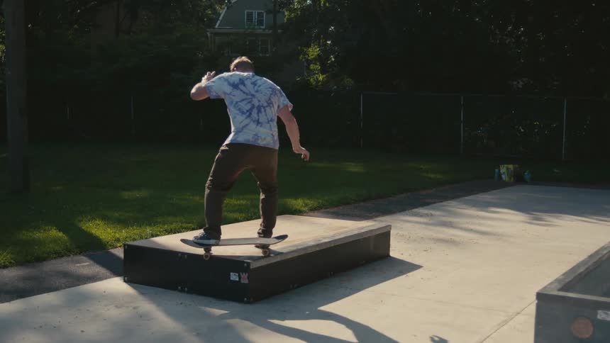 A man does a jump on his skateboard and the board flips around