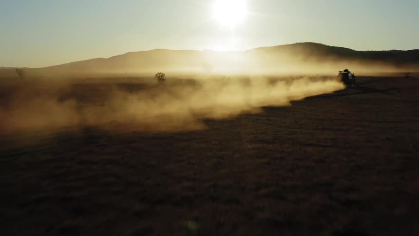 A car speeding over desert sand on a sunny day