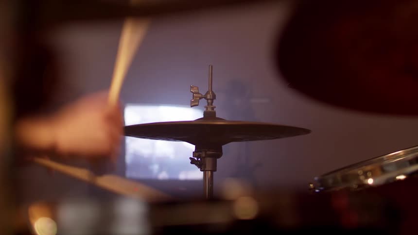 A person is playing the drums indoors