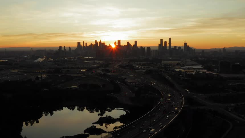 Vehicles on the interstate head toward downtown at sunrise