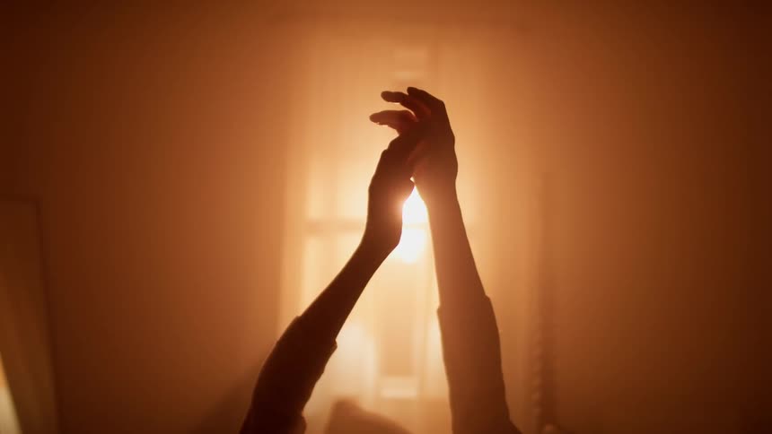 A person moves their hands around in the dark room