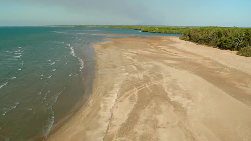 An aerial view of waves rolling in to the beach