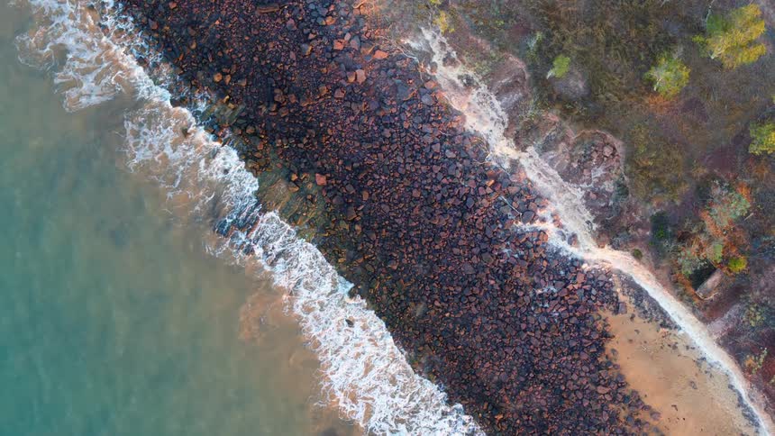 Aerial view of an ocean and beach coast is displayed