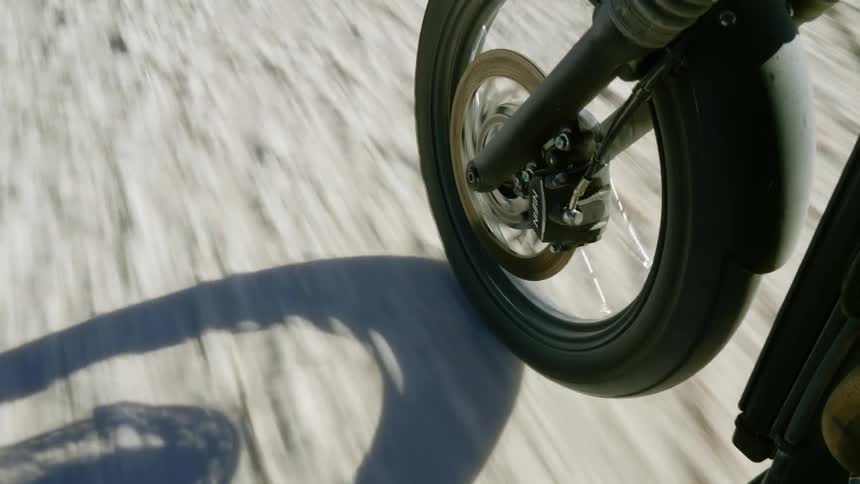 A motorcycle is driving in the sand
