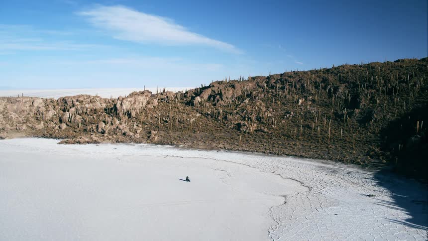 A person drives a snow mobile across the snowy landscape