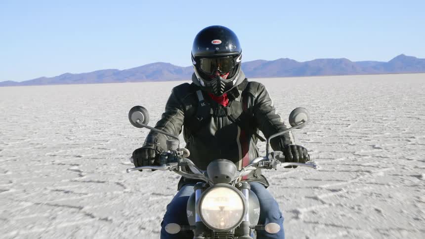 A person riding a motor bike in the desert