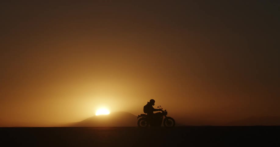 A person rides across the field at dusk