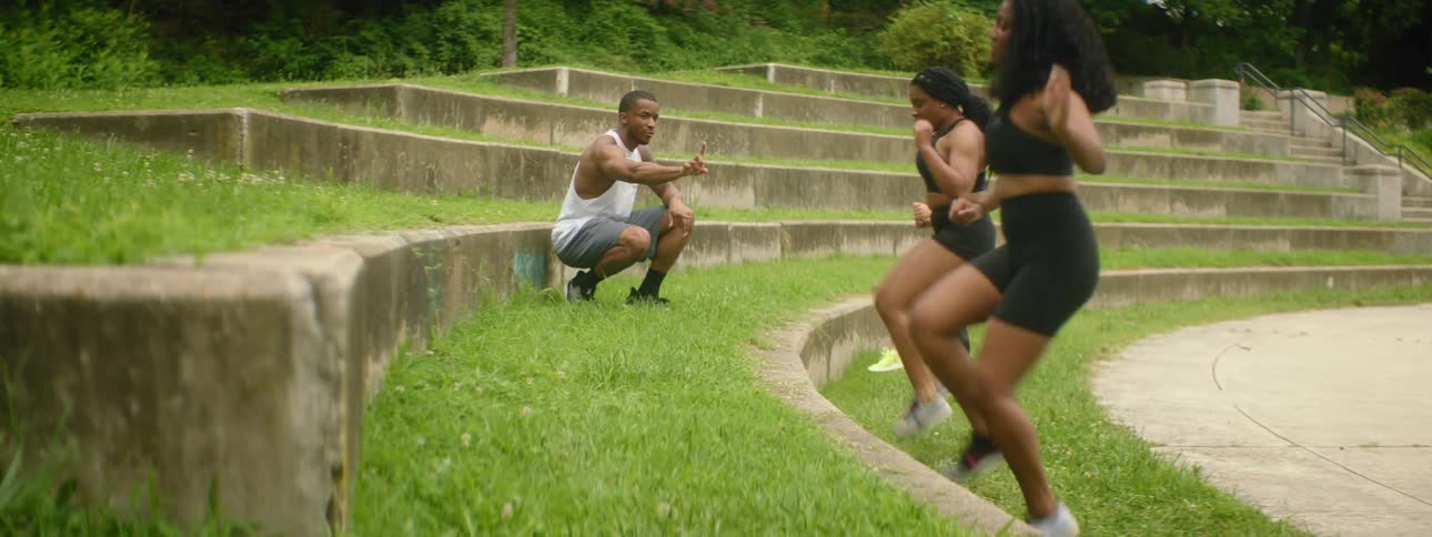 A man instructs three women as they exercise