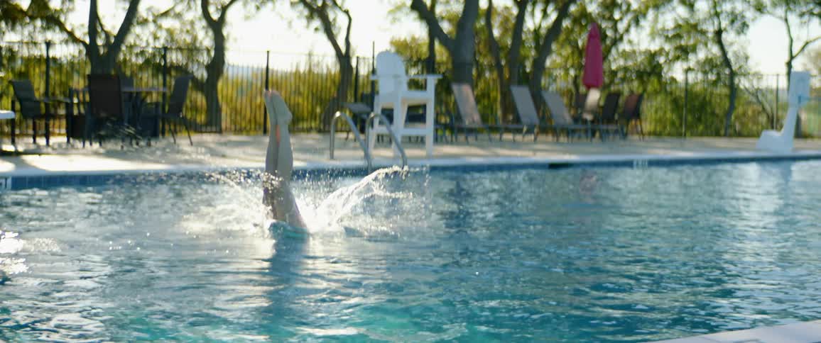 A female diving into a pool outside
