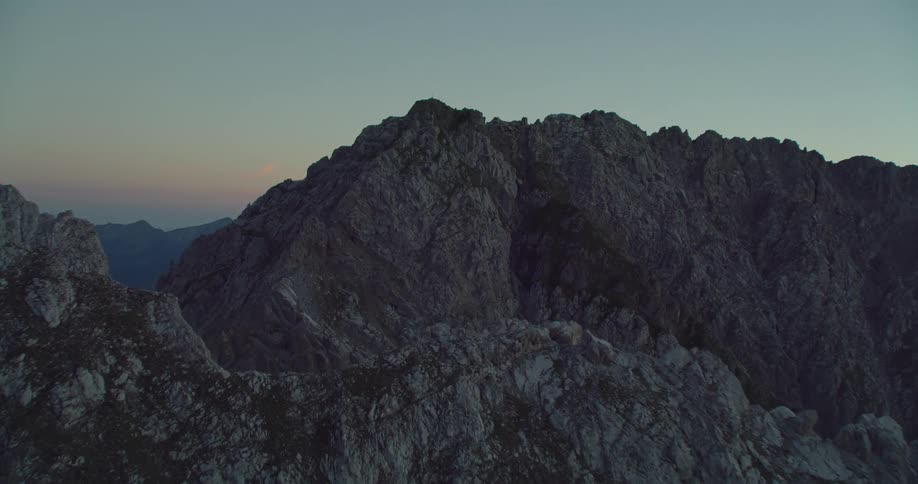 A stone mountain ridge under a clear evening sky