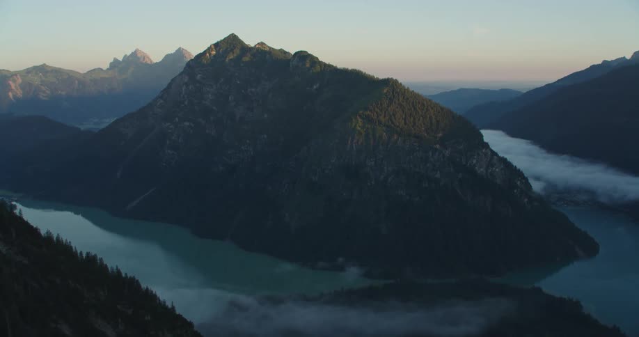 A mountain range and mountain peaks near the sky and clouds