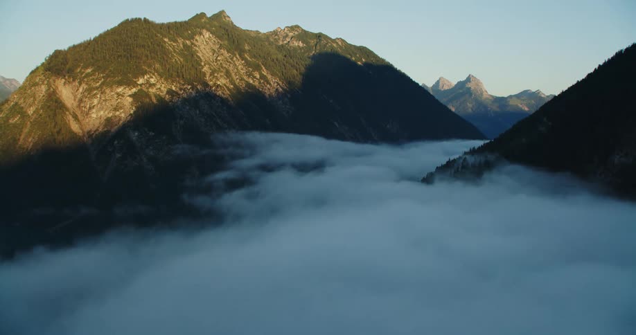 Heavy clouds in valley between tall mountains